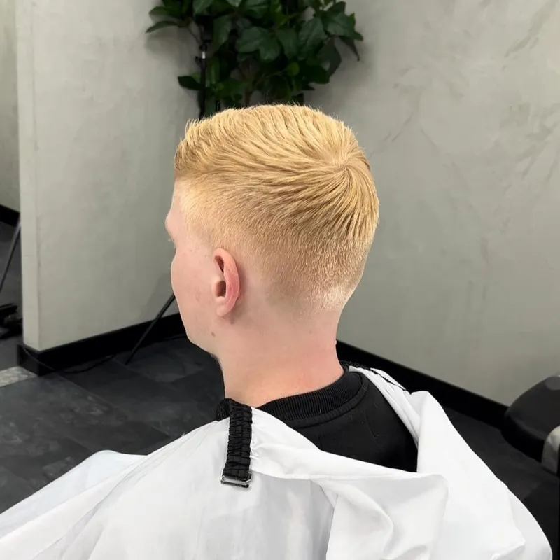 Achteraanzicht van geblondeerd haar met een korte skin fade in de nek